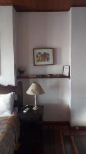 萨尔瓦多Bed & breakfast Villa Carmo的卧室,床边的桌子上放着一盏灯