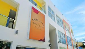 长滩岛Kamusta Boutique Hotel的建筑物一侧的橙色标志