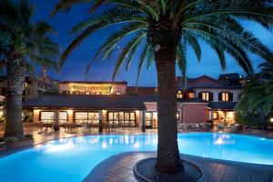 圣特雷莎加卢拉科拉拉洛酒店的酒店前方的棕榈树游泳池