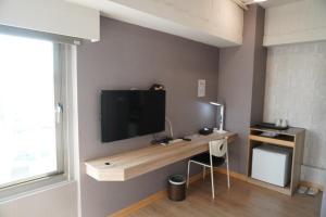 台南台南嘉园旅店的一间设有一张桌子的房间,墙上有一台电视机