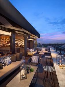 雅加达ARTOTEL Thamrin Jakarta的一座大楼内一个带沙发和桌子的屋顶露台