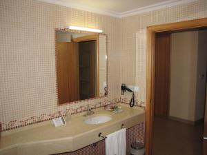 庞特维德拉罗姆酒店的一间带水槽和镜子的浴室