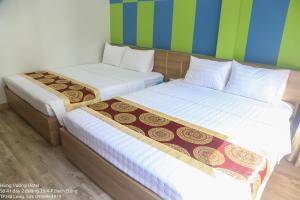 下龙湾Hùng Vương Hotel Hạ Long的两张睡床彼此相邻,位于一个房间里