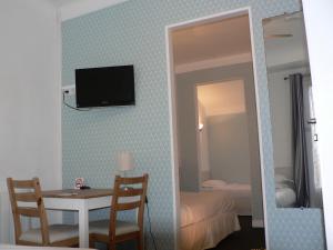 比亚里茨阿利扎斯酒店的一间设有桌子的房间和墙上的电视