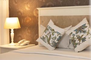 胡志明市Vilion Central Hotel & Spa的一间卧室配有带枕头和台灯的床