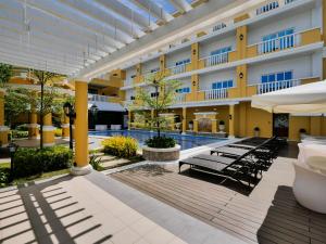 科隆巴拉望科隆阳光酒店的酒店庭院设有椅子和游泳池