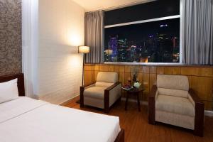 胡志明市Vilion Central Hotel & Spa的酒店的客房 - 带一张床、椅子和窗户