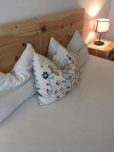 坎皮泰洛迪法萨Grohmann的一张带三个枕头的床和一盏灯