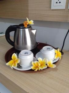 勒吉安汤姆宾馆的茶壶和三杯茶及桌上的鲜花