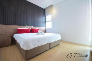 八打灵再也GT Home @ Sunway Nexis的一间卧室配有一张带红色枕头的大床