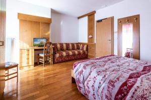 马洛斯科艾尔伯格布坎伊乌酒店的一间卧室配有一张床和一张沙发