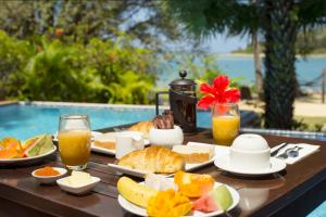 维拉港法图马鲁小屋酒店的一张桌子,上面有早餐食品和饮料