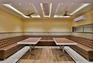 MundraHOTEL CENTRE POINT的一间会议室,配有棕色皮革座椅和桌子