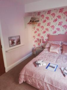 布里格The Lord Nelson的一间卧室配有粉红色的床,上面有一本书