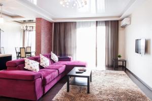 秋明Aparthotel Daudel Tyumen Center的客厅配有粉红色的沙发和桌子
