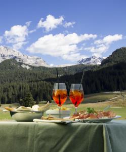 摩德纳迪-坎皮格里奥卡萨坎波酒店的一张桌子,上面放着两杯葡萄酒和食物