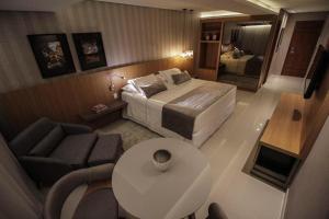 波多韦柳奥斯卡行政酒店的一间卧室配有一张床、一张沙发和一张桌子