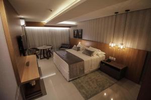 波多韦柳奥斯卡行政酒店的酒店客房设有床、桌子和电视。