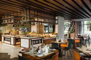 迪拜Millennium Al Barsha的一间带桌椅的餐厅和一间厨房