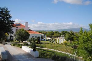 Aldeia GavinhaCAMBEIROS - Guest House的前面有花园的白色房子