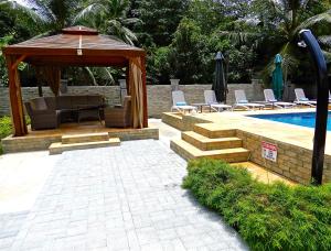 拉迪格岛帕斯永别墅的一个带凉亭和游泳池的庭院