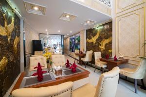 河内Le Beryl Hanoi Hotel的餐厅设有白色椅子和红色弓的桌子