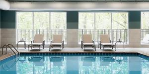 萨凡纳Holiday Inn Express & Suites - Savannah W - Chatham Parkway, an IHG Hotel的酒店游泳池设有桌椅和游泳池