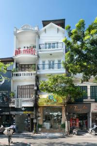 河内Le Beryl Hanoi Hotel的街道边高大的白色建筑