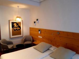 圣塞瓦斯蒂安桦木旅馆的一间卧室配有一张床和两把椅子