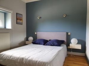 圣艾尼昂塔蒂戈瑟旅馆的一间卧室配有一张带蓝色墙壁的大床