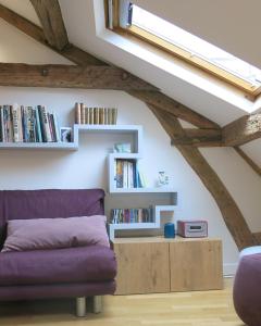 巴黎Marais Beaubourg的客厅配有紫色沙发和书架