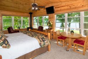 WalkerLeech Lake Resort Bed & Breakfast的卧室配有一张床和一张桌子及椅子