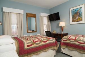 剑桥哈佛艾文豪斯酒店的酒店客房,设有两张床和镜子