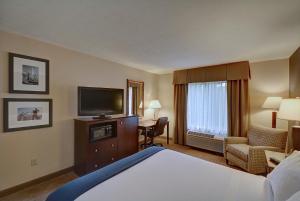 基恩基恩快捷假日酒店的配有一张床和一台平面电视的酒店客房