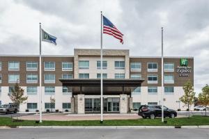 阿伦派克Holiday Inn Express & Suites Allen Park, an IHG Hotel的前面有两面旗帜的办公楼