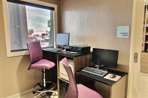 法戈法戈智选假日酒店 - West Acres的办公室,配有书桌、电脑和粉红色椅子