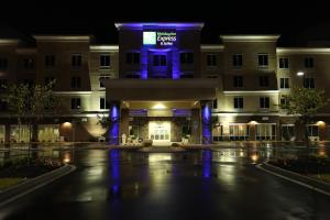 戈尔兹伯勒戈尔兹伯勒基地区智选假日套房酒店的夜间酒店,有蓝色的灯光标志