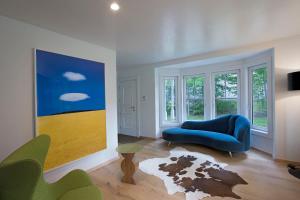 弗里波特Casa Alchimia的客厅配有蓝色沙发和绘画作品