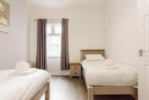 纽波特Handpost Lodge的带窗户的客房内设有两张单人床。