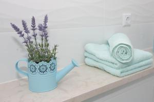 斯普利特Apartment Angelina的浴室柜台上带紫色花的蓝色花瓶