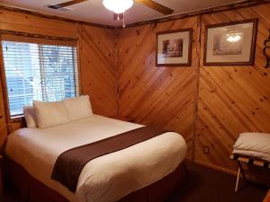 大熊湖大贝尔弗兰提尔酒店的卧室配有一张床铺,位于带木墙的房间内
