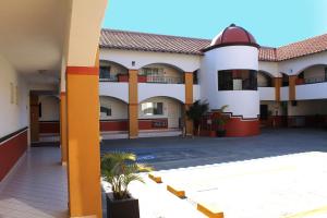 提华纳Del Mar Inn Playas的一座拥有橙色柱子和庭院的建筑