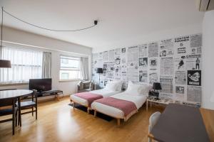 里斯本里斯波奈尔公寓酒店的一间卧室配有一张床和一堵报纸