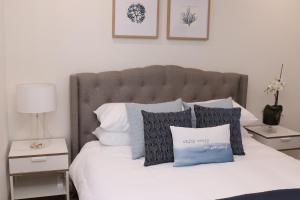 安特兰斯马林帕拉德3/32水景公寓的一张带蓝色和白色枕头的床