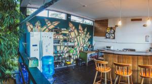 圣伊格纳西奥Bella's Backpackers Cayo的客房设有带椅子的酒吧和冰箱。
