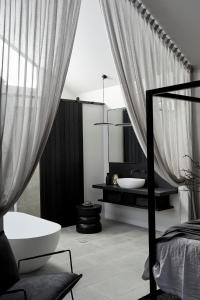 拜伦湾拜伦湾鲍尔酒店的黑白浴室设有浴缸和水槽