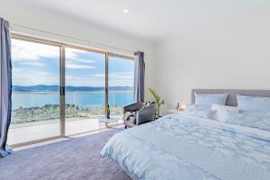霍巴特Nature & Relax House, Panoramic sea view, Free parking 37的一间卧室设有一张床和一个大窗户