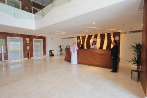 吉达Taj Jeddah Hotel Apartment的站在大堂的新娘和新郎
