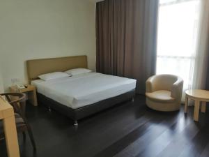 哥打京那巴鲁芒亚酒店的卧室配有床、椅子和窗户。