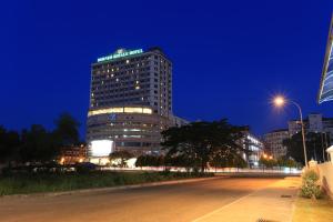 斗湖Borneo Royale Hotel的一座高大的建筑,晚上有标志